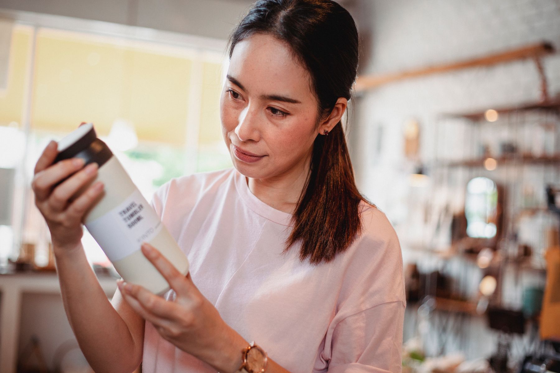 Shopper looking at the label on a large cosmetic bottle
