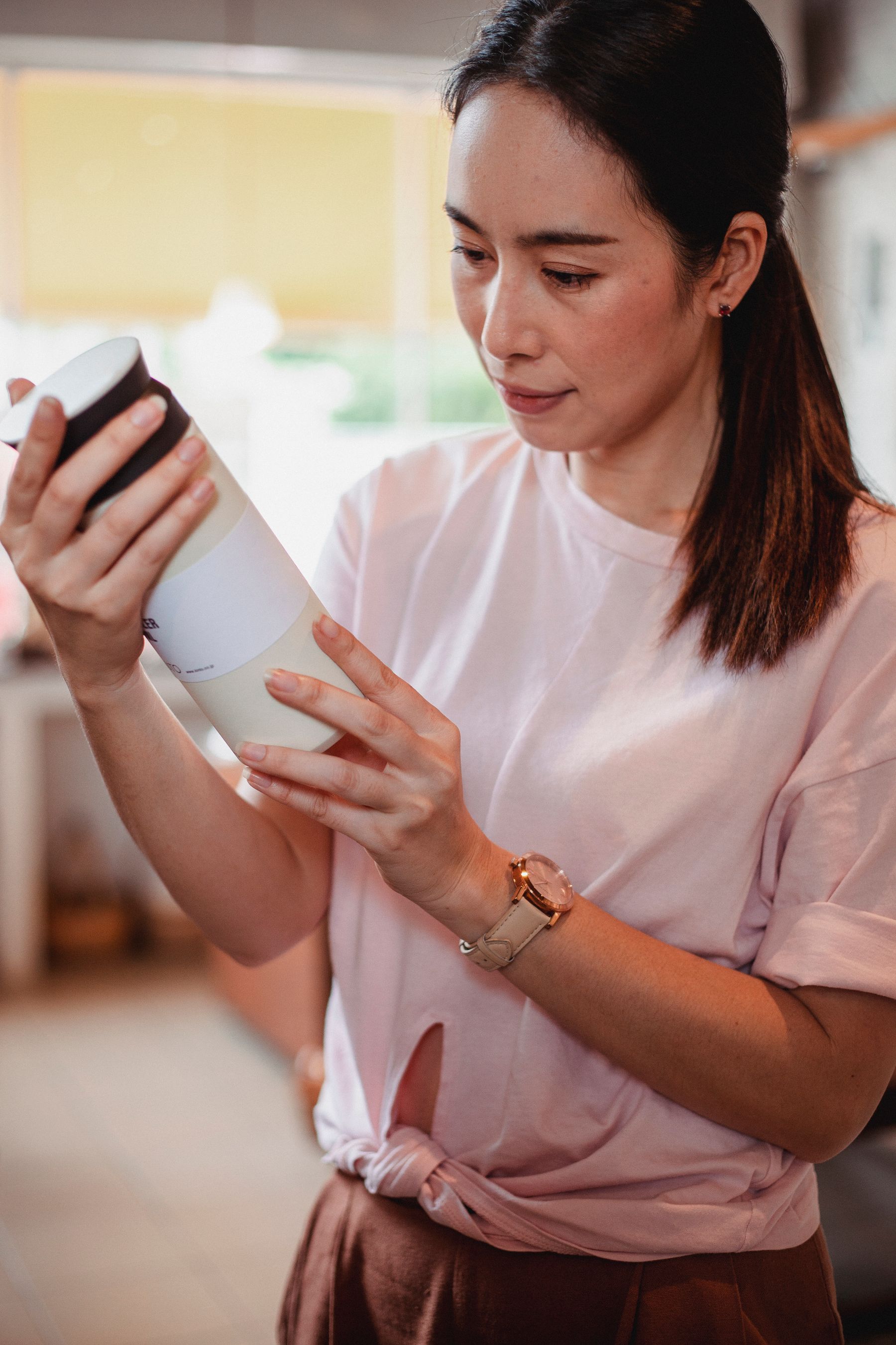 Person inspecting package information on a cosmetic bottle