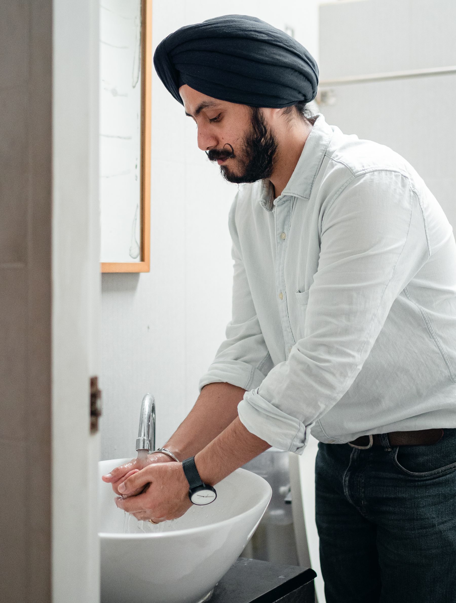 Man washing his hands at a bathroom sink.
