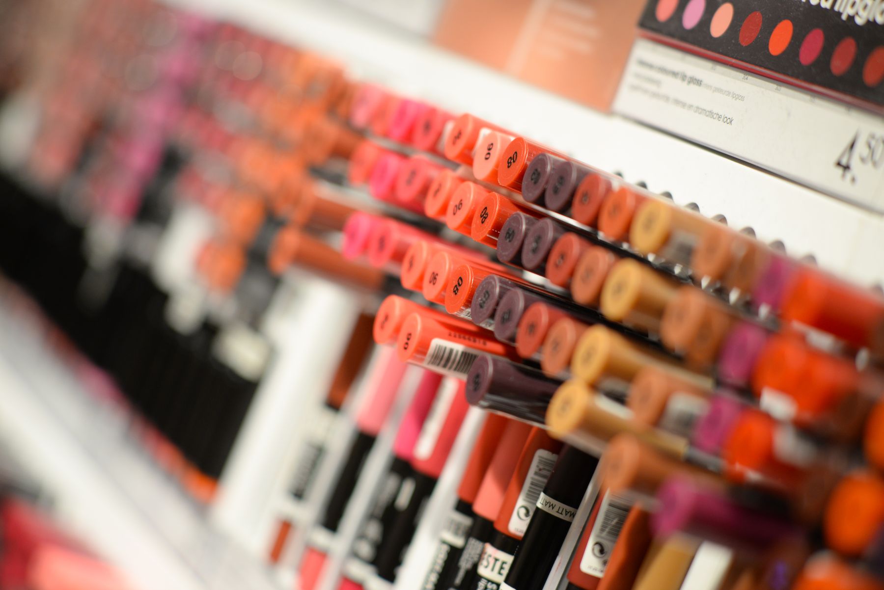 Rows of lip products in a shop with TESTER wording on packages