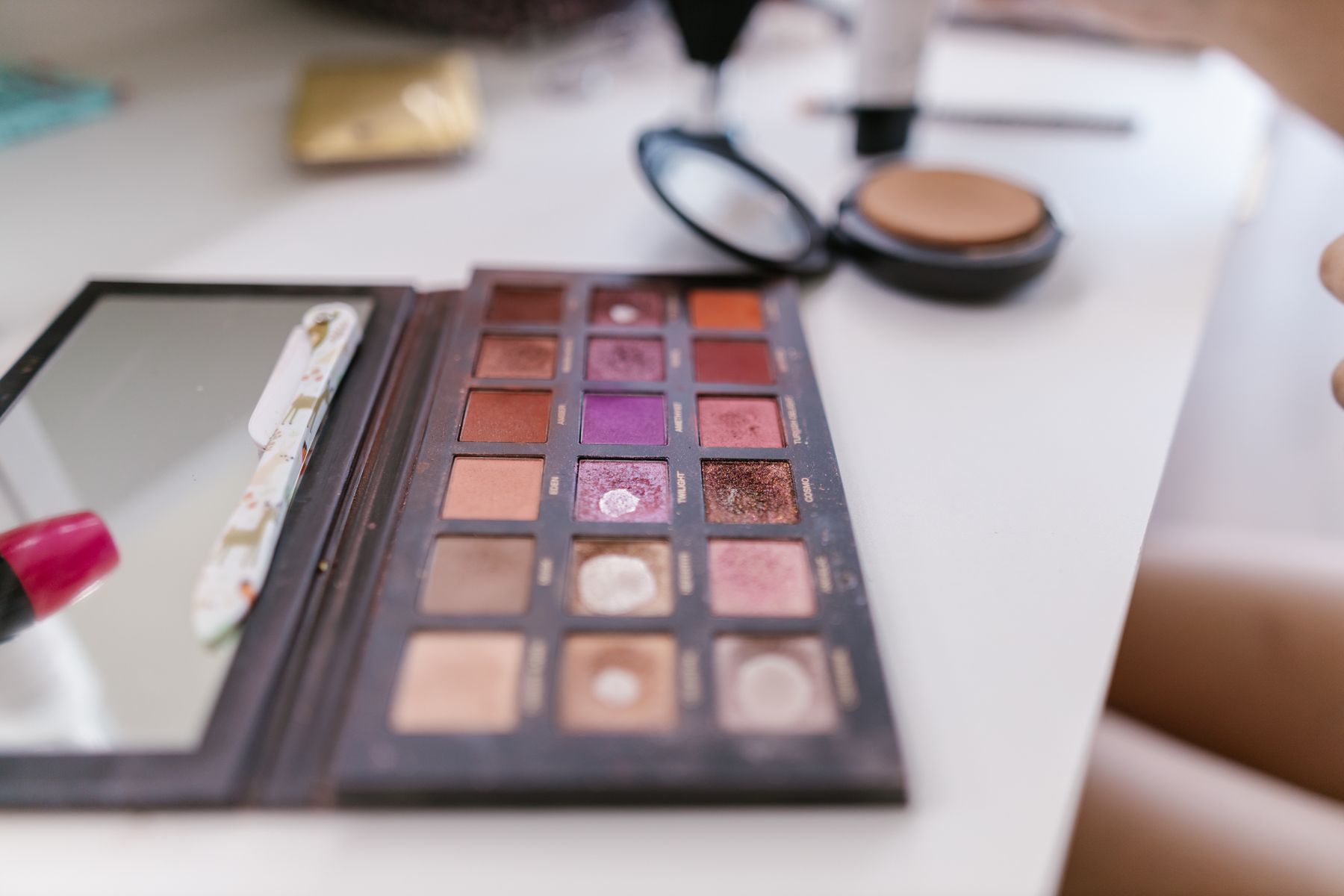 Open eyeshadow palette with visibly used powder pans